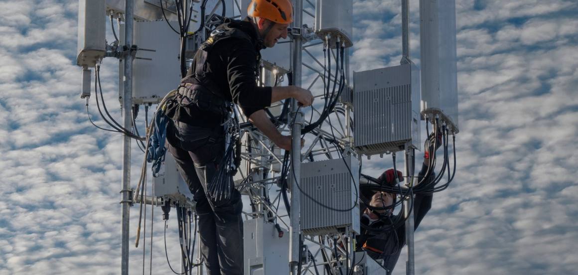 Deux techniciens en cordes travaillent sur les antennes d’un pylône mobile
