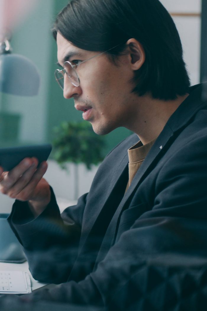 Un homme en train de téléphoner, assis à son bureau
